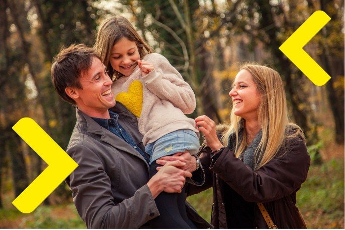 mama i tata u parku igraju se i smiju s kćeri, tata drži kćer u naručju 